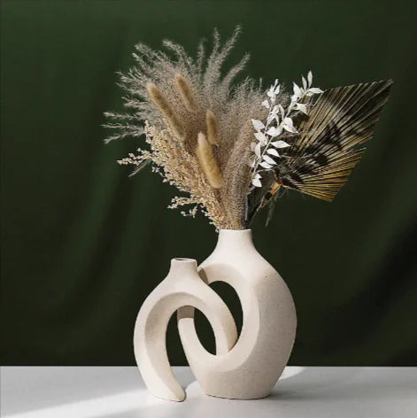 Decorative vase with dried plants against a dark green background
