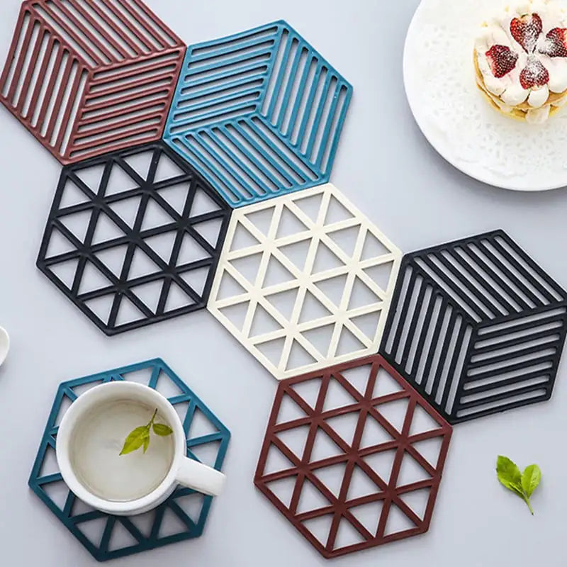 Hexagonal coasters in various colors on a light surface with a cup and dessert.