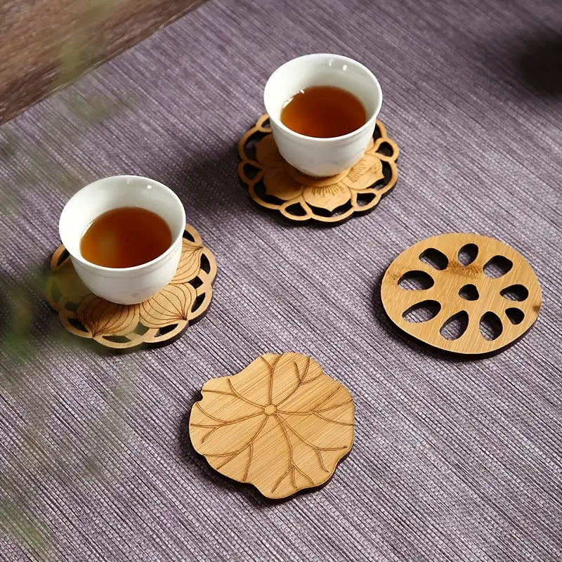 Two white cups with tea on wooden coasters on a textured surface