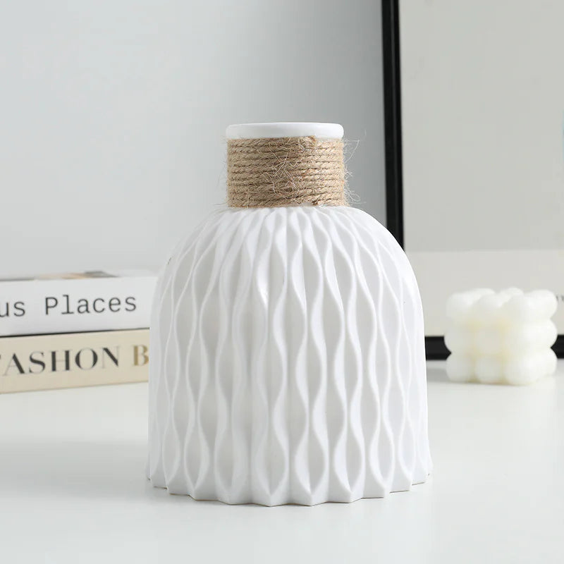 White textured vase with a natural rope handle on a light surface.