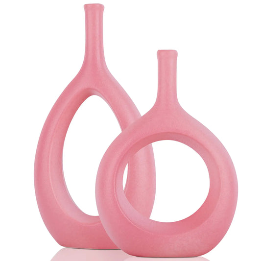 Two pink ceramic vases with a modern design on a white background