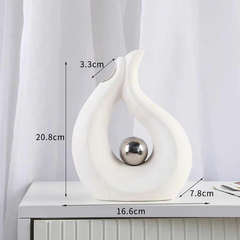 White decorative vase with a silver ball on top, shown with measurements against a white curtain background.